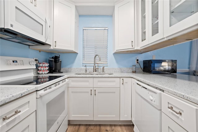 kitchen with light hardwood / wood-style flooring, sink, white cabinetry, light stone counters, and white appliances