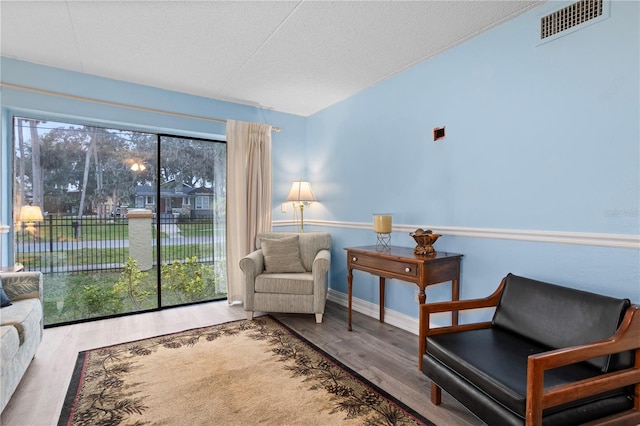 living area featuring hardwood / wood-style flooring and a textured ceiling