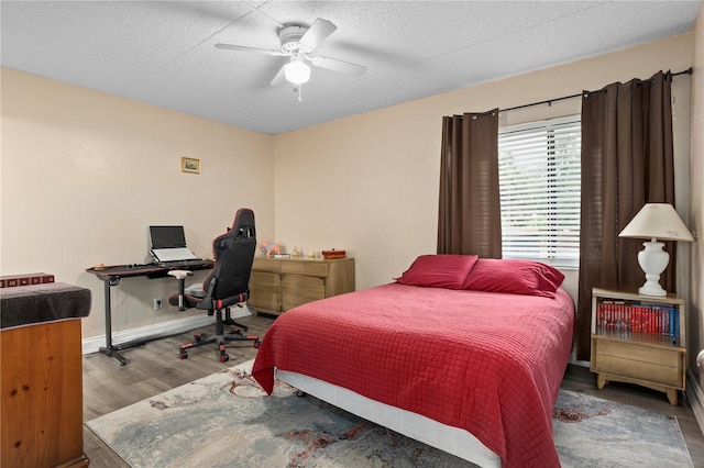 bedroom featuring ceiling fan, hardwood / wood-style floors, and a textured ceiling