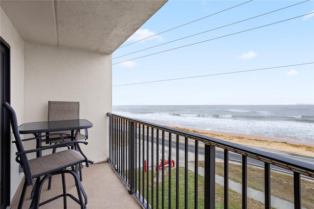 balcony featuring a beach view and a water view