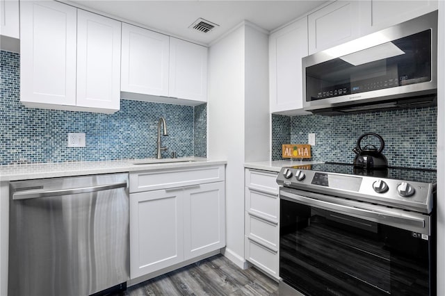 kitchen with white cabinets, appliances with stainless steel finishes, and tasteful backsplash