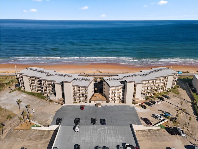 bird's eye view featuring a water view and a beach view