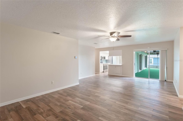 unfurnished living room with ceiling fan, light hardwood / wood-style flooring, and a textured ceiling