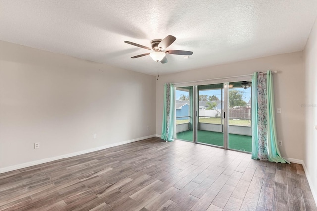 spare room featuring ceiling fan, wood-type flooring, and a textured ceiling