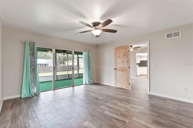 empty room featuring hardwood / wood-style flooring and a textured ceiling