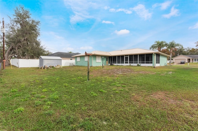 rear view of property featuring a sunroom and a yard