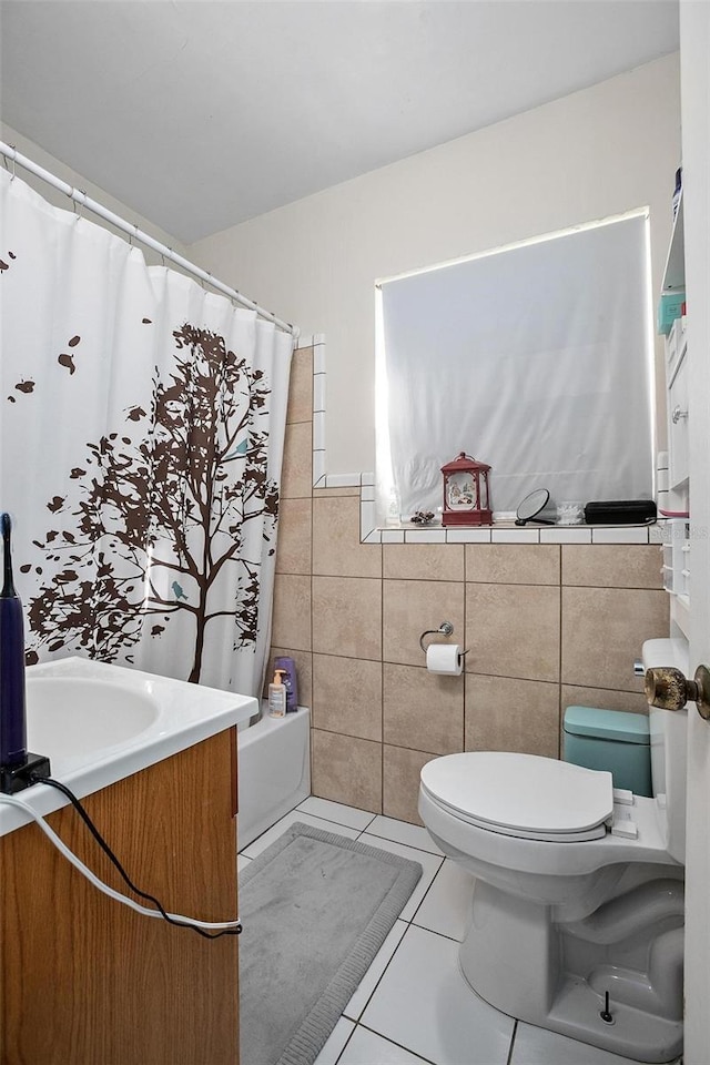 full bathroom with vanity, tile patterned flooring, toilet, shower / bath combo with shower curtain, and tile walls