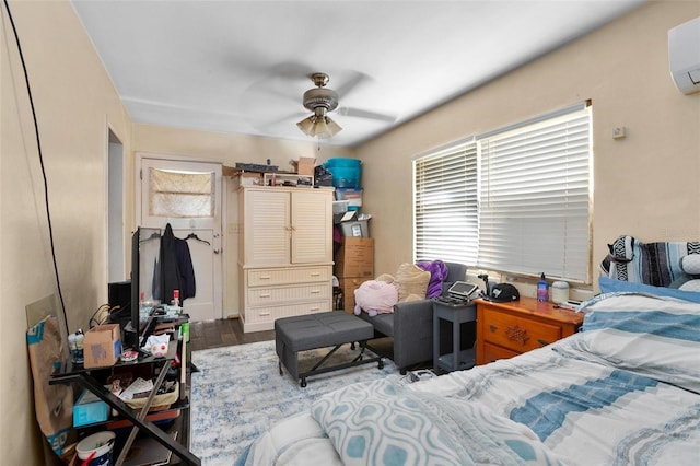 bedroom featuring a wall mounted AC, dark hardwood / wood-style flooring, and ceiling fan