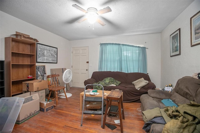 living room with a textured ceiling, hardwood / wood-style flooring, and ceiling fan