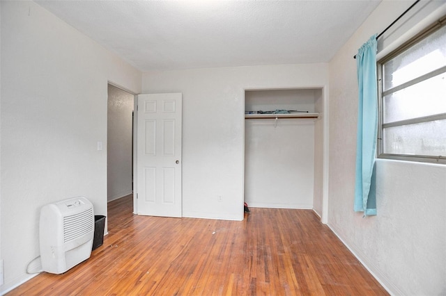 unfurnished bedroom featuring a closet and hardwood / wood-style flooring