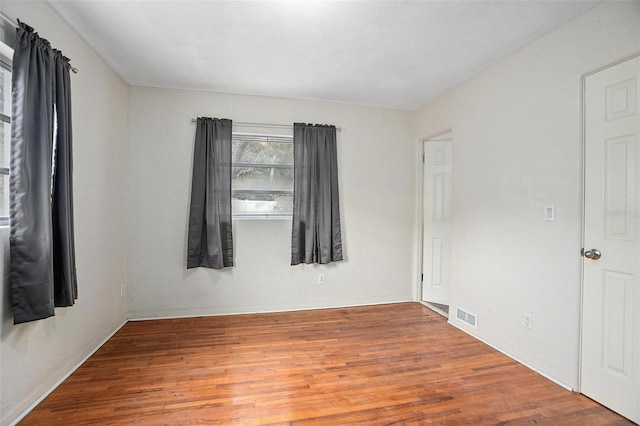 unfurnished room with hardwood / wood-style floors