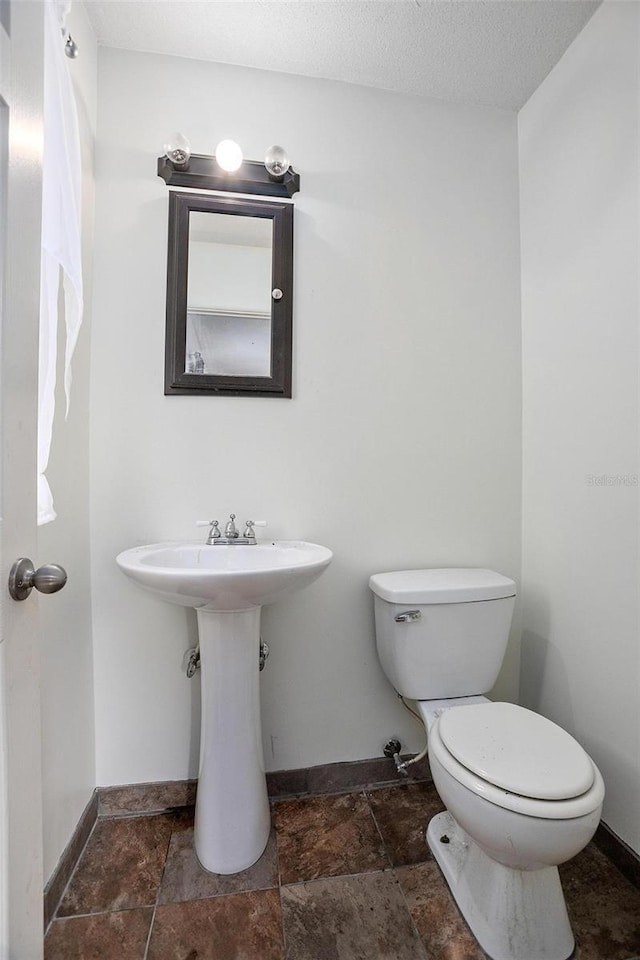 bathroom featuring sink, a textured ceiling, and toilet