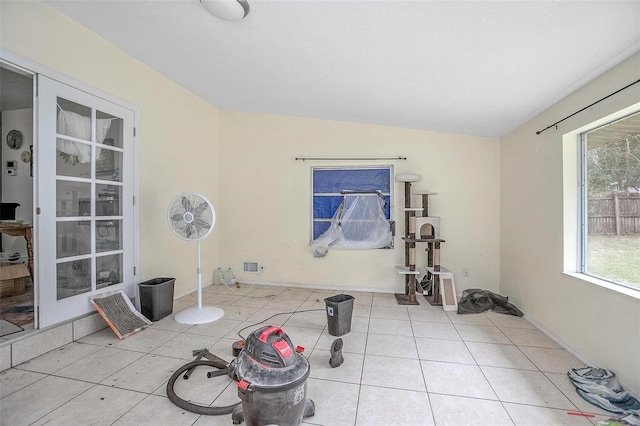 workout area with light tile patterned floors and lofted ceiling