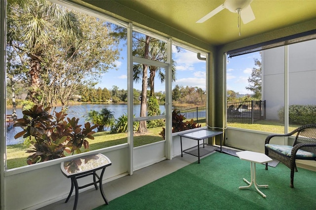 sunroom / solarium with a water view and ceiling fan