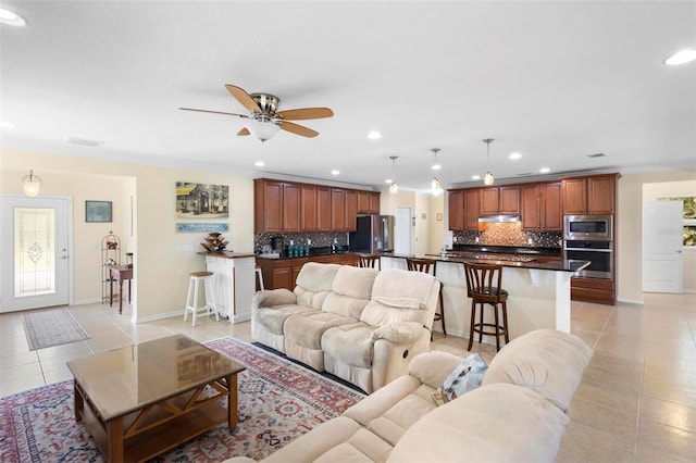 tiled living room featuring ceiling fan and crown molding