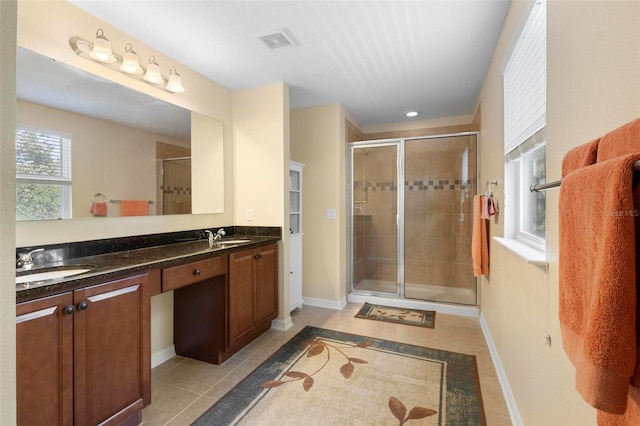 bathroom featuring vanity, tile patterned floors, and a shower with shower door