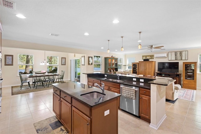 kitchen featuring a kitchen island with sink, sink, stainless steel dishwasher, ceiling fan, and decorative light fixtures