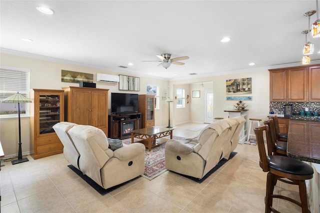 living room with light tile patterned flooring, a wall mounted AC, crown molding, and ceiling fan