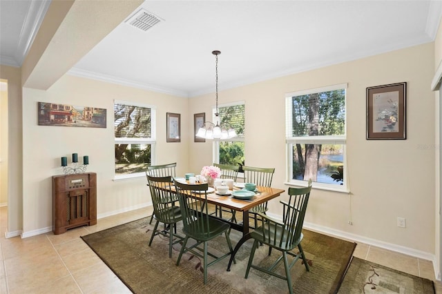 tiled dining area featuring crown molding and a chandelier