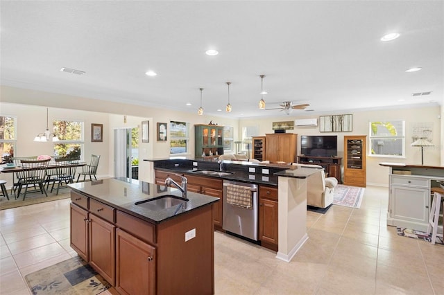 kitchen with ceiling fan, sink, stainless steel dishwasher, decorative light fixtures, and a kitchen island with sink