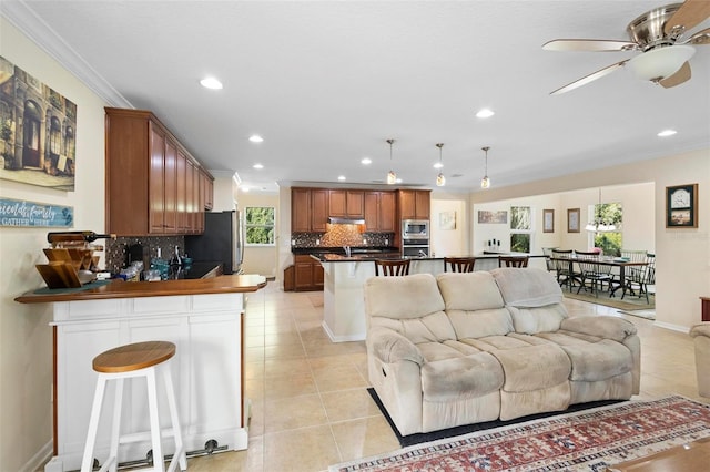 tiled living room with a wealth of natural light, crown molding, and ceiling fan