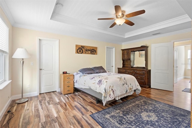 bedroom featuring a raised ceiling, ceiling fan, and ornamental molding