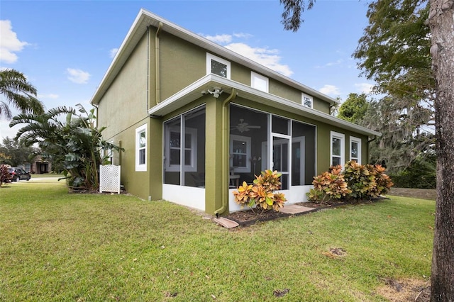 view of side of home featuring a sunroom and a yard