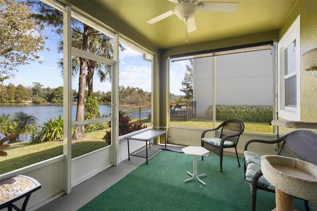 sunroom / solarium with ceiling fan and a water view