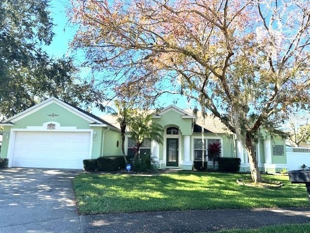 single story home with a garage and a front lawn