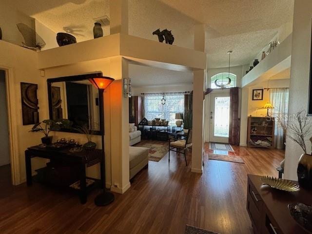 foyer entrance with ceiling fan, high vaulted ceiling, a textured ceiling, and hardwood / wood-style flooring