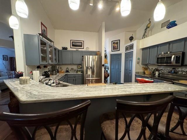 kitchen featuring kitchen peninsula, pendant lighting, and appliances with stainless steel finishes