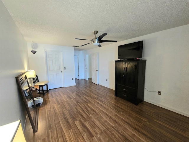 interior space with a textured ceiling, dark hardwood / wood-style flooring, and ceiling fan