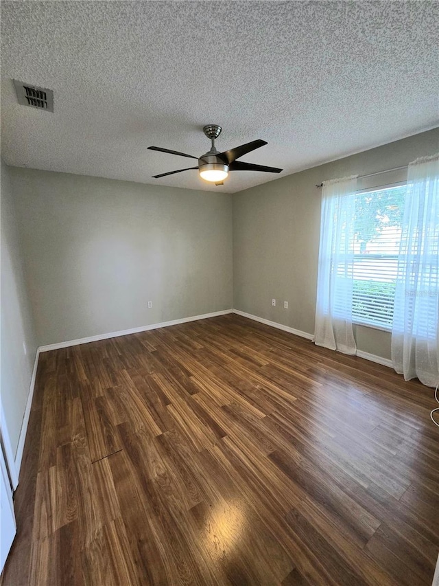 empty room featuring a textured ceiling, dark hardwood / wood-style floors, and ceiling fan