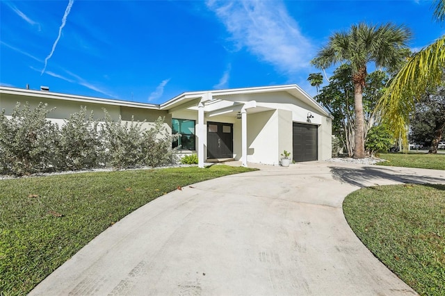 view of front of property featuring a front lawn and a garage