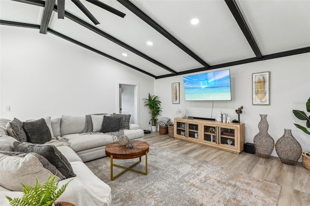 living room with light hardwood / wood-style flooring and lofted ceiling with beams