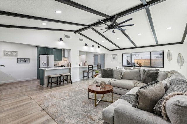 living room featuring ceiling fan, light hardwood / wood-style floors, and lofted ceiling with beams