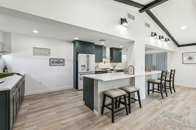 kitchen featuring a breakfast bar, vaulted ceiling with beams, light wood-type flooring, kitchen peninsula, and high end white refrigerator