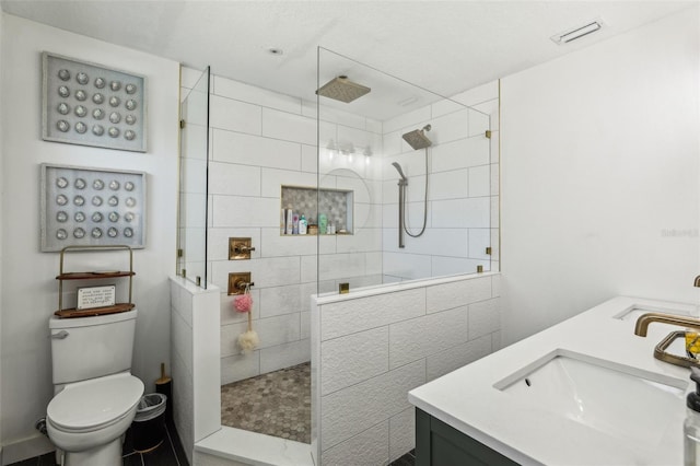 bathroom featuring vanity, toilet, and tiled shower