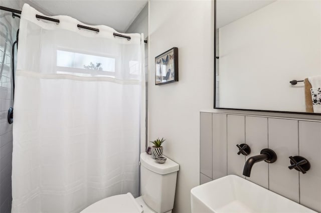 bathroom featuring curtained shower and toilet