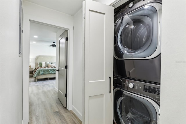 washroom with ceiling fan, light wood-type flooring, and stacked washing maching and dryer