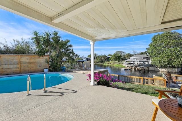 view of swimming pool featuring a water view and a patio area