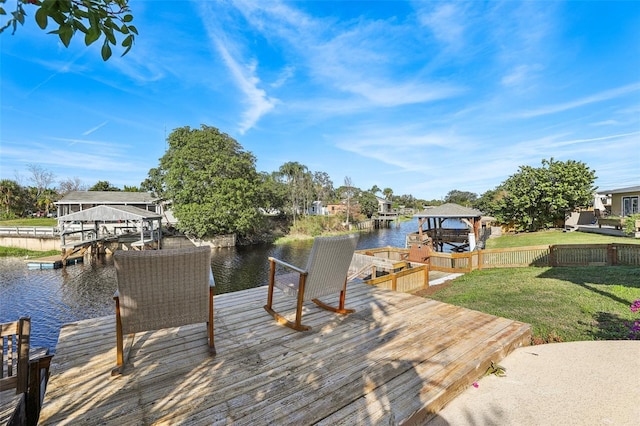 view of dock with a water view and a yard