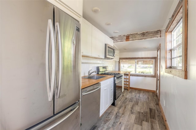 kitchen with white cabinets, sink, appliances with stainless steel finishes, and tasteful backsplash