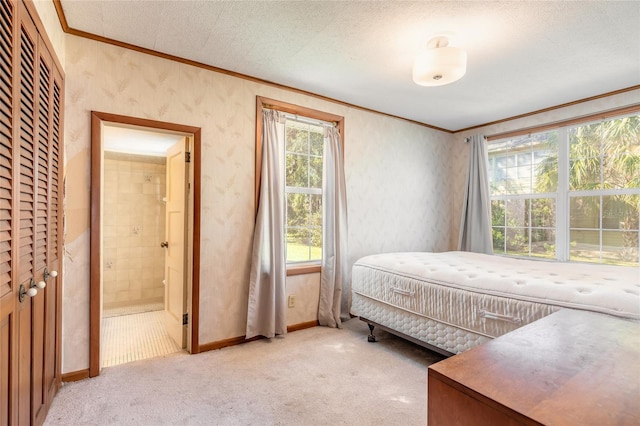 bedroom featuring crown molding, light carpet, and ensuite bath