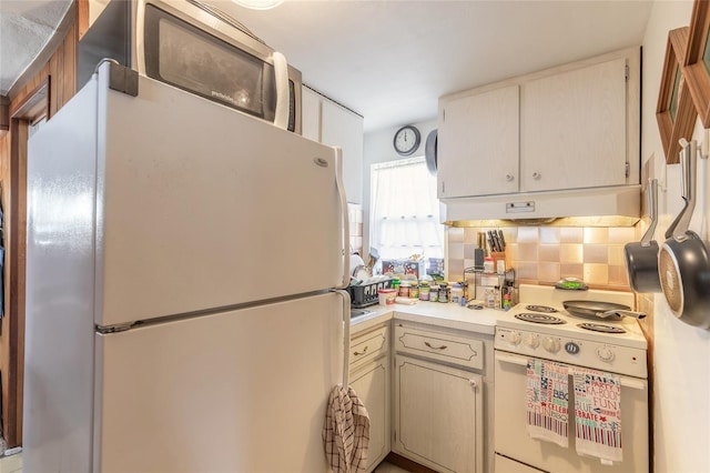 kitchen featuring white appliances and tasteful backsplash