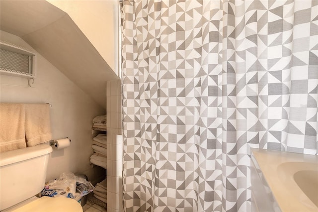 bathroom featuring vaulted ceiling and toilet