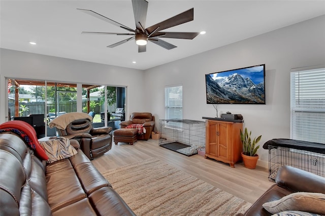 living room featuring light hardwood / wood-style flooring and ceiling fan