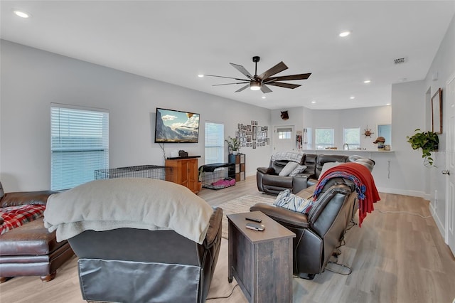 living room with ceiling fan and light hardwood / wood-style floors