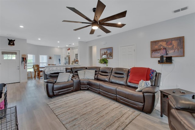 living room featuring ceiling fan and light hardwood / wood-style floors