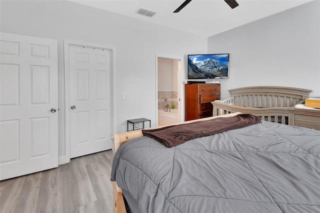 bedroom with light wood-type flooring, ensuite bath, ceiling fan, and lofted ceiling